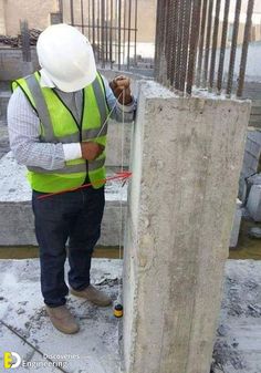 a construction worker measuring the height of a concrete slab