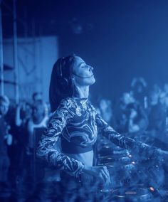 a woman dj mixing in front of a crowd