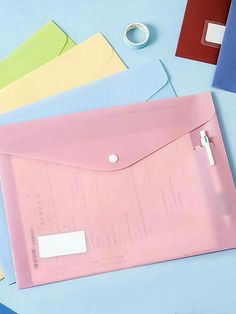 an open pink envelope sitting on top of colorful papers