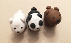 three small toy animals sitting next to each other on a white counter top with brown and black spots