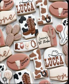 many decorated cookies are arranged on a white tablecloth with the words lucas written in large letters