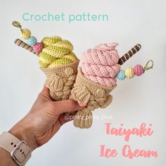 crocheted ice cream cones with candy toppings on them are being held by a hand