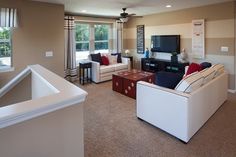 a living room filled with furniture and a flat screen tv on top of a wall