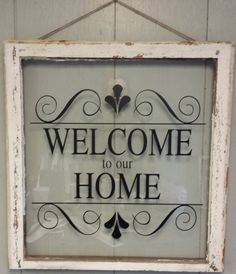 an old window with a welcome sign on it's front and the words welcome to our home written in black