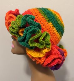 a crocheted hat with multicolored ruffles is on top of a mannequin head