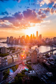 an aerial view of the city and bridge at sunset