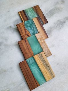 three pieces of wood with green glass in the middle on a white marble countertop