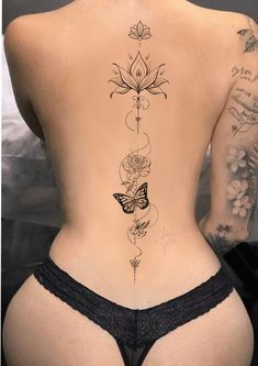 the back of a woman's body with tattoos on it