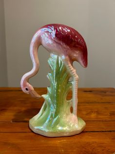 a pink flamingo figurine sitting on top of a wooden table