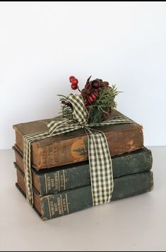 stack of old books tied with a ribbon and pine cones on top, sitting next to each other