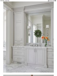 a white bathroom with two sinks and mirrors