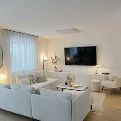 a living room filled with furniture and a flat screen tv mounted on the wall above it