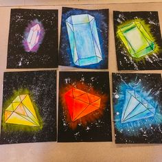 four different colored paintings on black paper with white and blue stars in the sky behind them