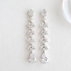 Long Marquise-Cut Cubic Zirconia Crystal Bridal Earring Slim and elegant marquise earrings are made with sparkly cubic zirconia in a leafy design. These marquise crystals drop from round ear tops to give it a perfect length. Made with high-quality cubic zirconia set in rhodium plated brass these earrings would be a seamless match with any bridal and wedding gowns. With lots of sparkle and bling, these earrings are comfortable on the ears weighing about 3 grams each.These marquise-shaped cubic zi Marquise Bridal, Cubic Zirconia Bridal Earrings, Gold Bracelet Wedding, Crystal Wedding Necklace, Ear Tops, Pearl Drop Earrings Bridal, Bride Bracelet, Wedding Earrings Studs, Silver Pearl Bracelet