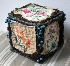 a decorative box with flowers and beads on it