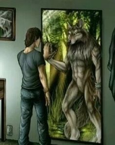 a man standing in front of a mirror next to a wolf painting on the wall