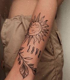 a woman's arm with a sun and leaves tattoo design on it that says i love you