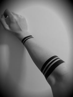 black and white photo of arm with wristbands in the shape of two stripes