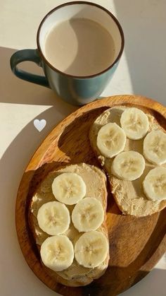 two slices of banana bread sitting on top of a wooden plate next to a cup of coffee