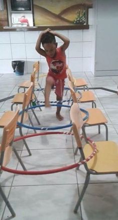 a little boy standing on top of a set of chairs