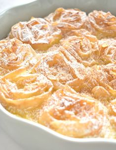 a baked dish with powdered sugar on top in a white casserole dish