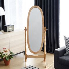 an oval mirror stands in the middle of a living room