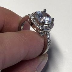 This ring is FULL OF BLING! Sterling Silver Plated Ring with white cubic zircon stones. Square set surrounded by small white cubic zircon stones stacked with a 2 CT cushion cut center white cubic zirconia stone. Channel setting. This is a SIZED ring, please see available sizes. VIDEO: https://www.facebook.com/wickedwondersVIPbling/vid... #Princess #Bling #RingBling Diamond White Princess Cut Crystal Promise Ring, Cubic Zirconia Princess Cut Promise Rings, Princess Cut Cubic Zirconia Promise Rings, White Moissanite Crystal Ring With Round Cut, Promise Princess Cut Birthstone Ring With Cubic Zirconia, White Gold Cubic Zirconia Princess Cut Birthstone Ring, Cubic Zirconia Princess Cut Ring With Center Stone, Princess Cut Cubic Zirconia Ring With Center Stone, White Cubic Zirconia Diamond Ring For Promise