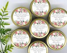 six personalized wedding favors in gold tins with floral designs and names on them