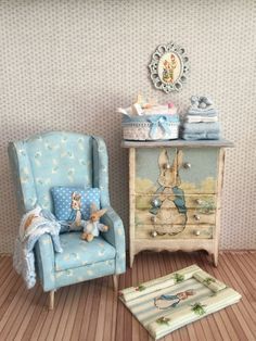 a doll house bedroom with a blue chair and small dresser next to the toy bed