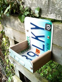 a close up of a wooden bench with a license plate holder on it's back