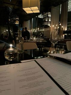 a restaurant with menus and wine glasses on the table