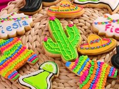 decorated cookies in the shape of cactuses and sombreros on a wicker basket