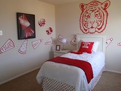 a bedroom decorated in red and white with a tiger head on the wall