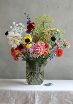 a vase filled with lots of different colored flowers