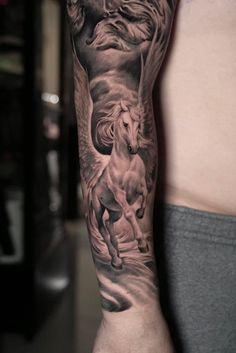 a man's arm with a horse and lion tattoo on it