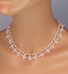 "This Bridal Beaded Snowflake Statement Necklace is The Rochelle. You will receive the necklace and earrings. This is the perfect Winter Wedding jewelry set. The Rochelle is a lace like necklace that adds just the right amount of sparkle for a bride who's style is elegant and \"middle of the road\"  but still wants to make a statement.  This is created with 4mm Swarovski clear crystals, 4mm Swarovski pearls and clear seed beads. It is 19\" in length and has a solid sterling silver clasp. The matching earrings have a 6mm pearl topped with a 5 mm crystal and a 4mm pearl. The ball hook earring wires are solid sterling silver. This exact set is ready to ship and this is the last one I will be making. I am in AZ so it is usually 2 days to either coast, but allow more time just in case. If you a Winter Wedding Jewelry, Beaded Bridal Jewelry, Unique Wedding Jewelry, Snowflake Necklace, Wedding Jewelry Set, Wedding Bridesmaid Jewelry, Winter Bride, Lace Necklace, Wedding Winter