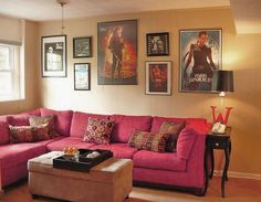 a living room filled with red couches and pictures on the wall above each sofa