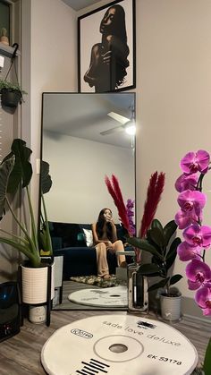 a woman taking a selfie in front of a mirror with flowers on the table