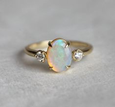 Buy gold opal ring and opal engagement rings. We offer a beautiful oval opal ring with two diamonds on the side at best prices. Shop Now! FREE shipping worldwide! Oval Opal Ring, Engagement Ring Opal, Gold Opal Ring, Opal And Diamond Ring, Opal Diamond Ring, Opal Engagement Ring, Ring Opal, Opal Ring Gold, Opal Engagement