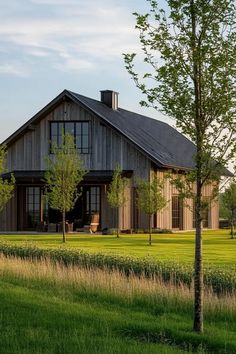 a large wooden house sitting on top of a lush green field next to a tree