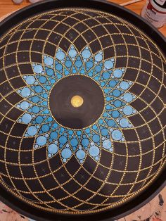 a black tray with blue and gold designs on the bottom is sitting on a table