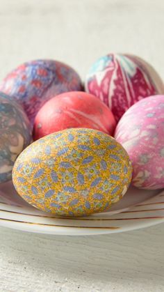 an assortment of painted easter eggs on a plate