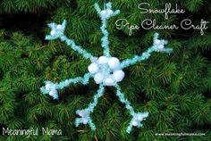 a snowflake ornament made out of plastic balls on a pine tree