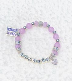 "\"Borahae'! Show your love for our Bangtan Boys with this delicately beautiful Genuine Purple Quartz and glass beaded bracelet. Silver metal and rhinestone accents. Made with smaller 8mm beads for a sweet dainty look! With Silver metal heart and purple pavé BTS logo charm . Size: 7.25\" stretches to fit most wrists comfortably." Bts Logo, Glass Beaded Bracelet, 8mm Beads, Purple Quartz, Metal Heart, Glass Beaded Bracelets, Bracelet Silver, Agate Beads, Arm Band