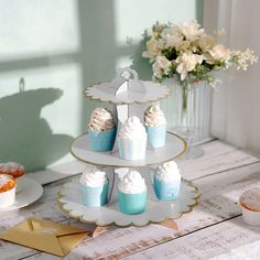 cupcakes are arranged on three tiered trays