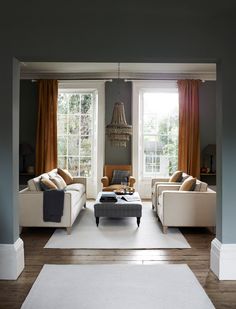 a living room filled with furniture and windows