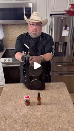 a man in a cowboy hat is making something on a counter top with two bottles