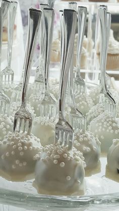 several forks are stuck into cupcakes with pearls on them