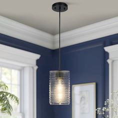 a light fixture hanging from the ceiling in a room with blue walls and white trim