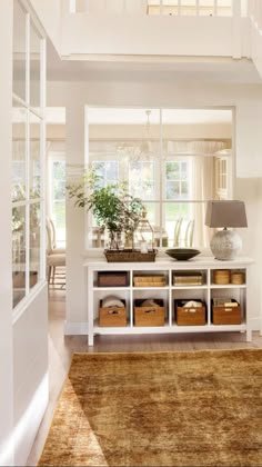 a living room filled with furniture and lots of storage under a stair case next to a window